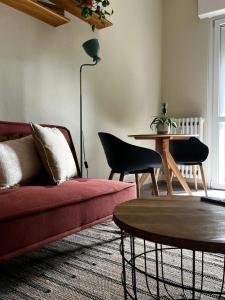 Una sala de estar con un sofá rojo y una mesa. en Tropical Cocoon in Monza, en Monza