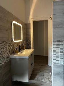 Un baño con un lavabo y un espejo en la pared. en Tropical Cocoon in Monza, en Monza