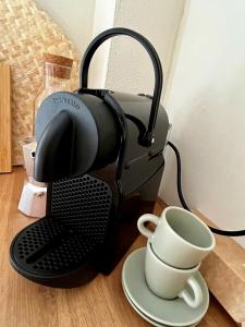 una cafetera y una taza sobre una mesa en Tropical Cocoon in Monza, en Monza