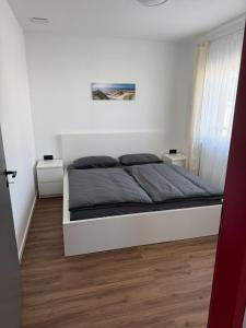 una camera da letto con un letto in una stanza bianca di Samtenssonne a Samtens