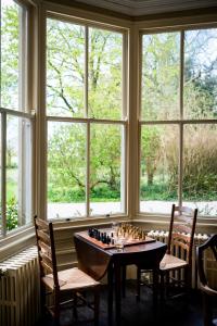 a room with a chess board on a table in front of windows at Charming 18th Century property in Topcliffe Station
