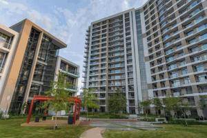 deux grands immeubles avec une structure rouge dans un parc dans l'établissement Menlyn Maine Residences 813, à Pretoria