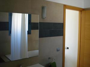 a bathroom with a mirror and a sink at Villa Romaní Apartament in Ciutadella +60 photos