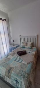 Una cama en un dormitorio con colcha. en KaiKaiView, en Port Nolloth