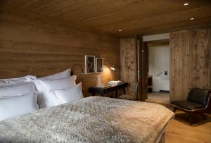 a bedroom with a bed and a desk and a chair at House Hannes Schneider Stuben in Stuben am Arlberg