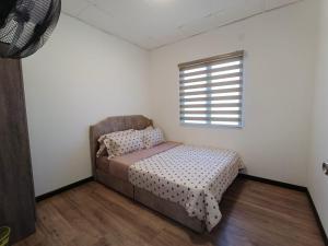 una piccola camera da letto con un letto e una finestra di Aura Homestay Selayang a Batu Caves
