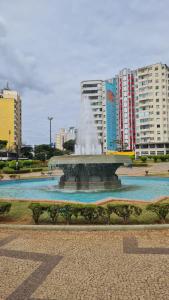 a fountain in the middle of a city with buildings at Seu Loft em BH, conforto e localização perfeita in Belo Horizonte