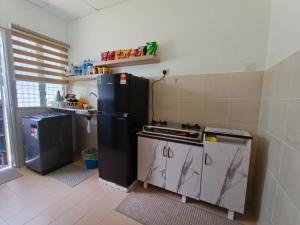 a kitchen with a black refrigerator and a stove at Aura Homestay Selayang in Batu Caves +5 photos