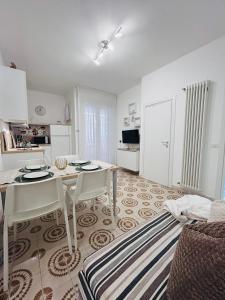 a kitchen and living room with a table and chairs at Angiolieri Flexrent - Immobiliare Abissinia in Riccione