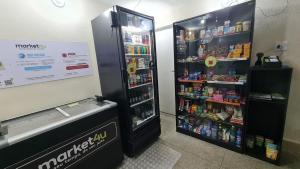 a soda machine in a store with its door open at Seu Loft em BH, conforto e localização perfeita in Belo Horizonte