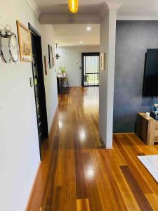 a living room with a hard wood floor and a flat screen tv at Quite and nature paradise in Byford