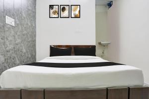 1 dormitorio con 1 cama blanca grande y 3 cuadros en la pared en Hotel O Maan In, en Bilāspur