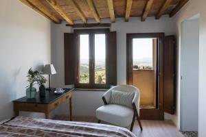 una camera da letto con un letto, una scrivania e una sedia di Palazzo Gramsci a Tatti