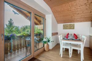 a dining room with a table and a balcony at Martin´s Alm in Friesenried