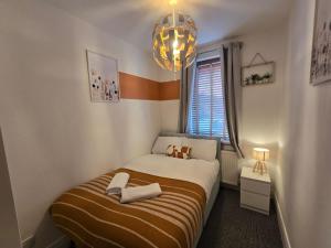 Habitación pequeña con cama y lámpara de araña. en Spacious 3BR Sleeps 6 Ideal for All Stays, en Dunston