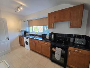 Una cocina con gabinetes de madera y un horno de estufa. en Spacious 3BR Sleeps 6 Ideal for All Stays, en Dunston