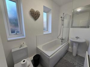 Un baño blanco con bañera y lavabo. en Spacious 3BR Sleeps 6 Ideal for All Stays, en Dunston