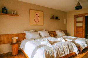 a bedroom with two beds with white sheets at Flooka Surf Yoga in Imsouane +29 photos