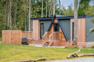 a small cabin with a porch and a deck at Landal Kenwick Woods in Louth