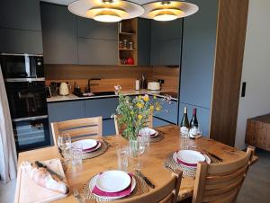 - une cuisine avec une table en bois, des assiettes et des verres à vin dans l'établissement NEW APT, 100m from ski lift, à Châtel