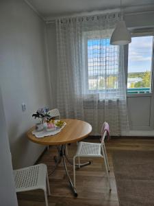 a table and chairs in a room with a window at Side Korterid in Rakvere