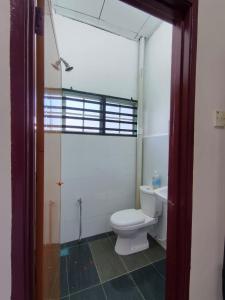 a bathroom with a toilet and a sink at Nariz Homestay Kuala Ketil in Kuala Ketil