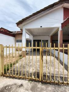 a yellow fence in front of a building at Nariz Homestay Kuala Ketil in Kuala Ketil
