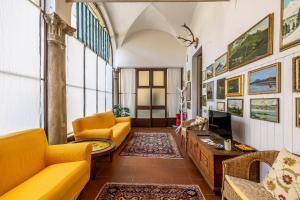 a living room with yellow furniture and a tv at Charme e storia apartment in Brescia center in Brescia
