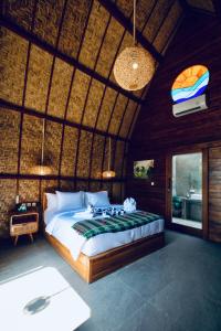 ein Schlafzimmer mit einem Bett in einem Zimmer mit einer Decke in der Unterkunft Corabelle Gili Air in Gili Air
