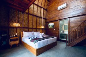 ein Schlafzimmer mit einem Bett in einem Zimmer mit Holzwänden in der Unterkunft Corabelle Gili Air in Gili Air