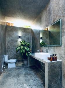 ein Badezimmer mit Waschbecken, Toilette und Spiegel in der Unterkunft Corabelle Gili Air in Gili Air + 59 Fotos