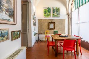 a dining room with a table and chairs and paintings at Charme e storia apartment in Brescia center in Brescia