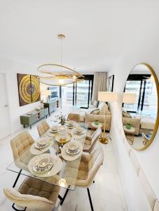 un salon avec une table, des chaises et un miroir dans l'établissement Azure Carmel Apartment Flamenca Village, à Orihuela Costa