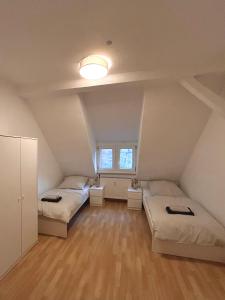 a attic room with two beds and a window at Monteurs- und Ferienwohnung Miltenberg in Miltenberg +3 photos