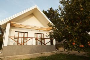 a house with an orange tree in front of it at Hotel Cider&Squash garden haus, Grncarska 6, Prnjavor in Prnjavor