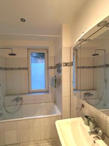 a bathroom with a tub and a sink and a window at Monteurs- und Ferienwohnung Miltenberg in Miltenberg