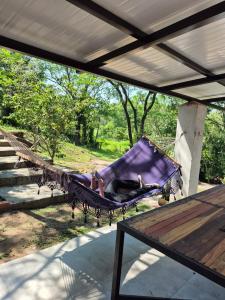 a person laying in a hammock on a porch at Descanso Del Mbocayaty in Mbocayaty