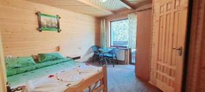 a bedroom with a bed and a table and a window at Villa Girska Sonata in Mykulychyn