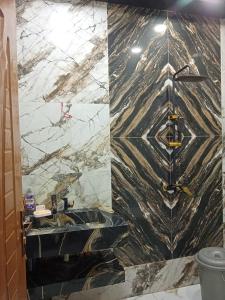 a bathroom with a sink and a marble wall at AL Imran villa in Lahore