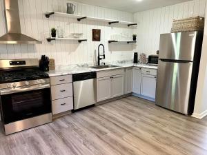 a kitchen with white cabinets and a stainless steel refrigerator at 4 Bed Ranch-Fire Pit-Pet & Kid Friendly-King Bed-Arcade in Columbus