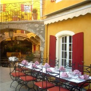 a table with red chairs and pink napkins on it at Hotel l'Oronge in Saint-Jean-du-Gard