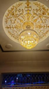 a large gold chandelier hanging from a ceiling at AL Imran villa in Lahore