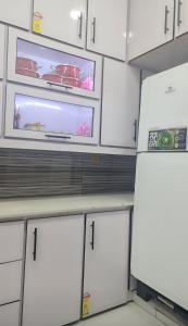 a kitchen with white cabinets and white appliances at AL Imran villa in Lahore