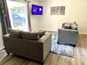 a living room with two chairs and a couch at 4 Bed Ranch-Fire Pit-Pet & Kid Friendly-King Bed-Arcade in Columbus