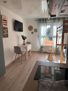 a living room with a table and a desk at Le cosy du Futuroscope in Jaunay-Clan