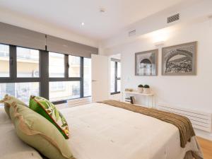 a bedroom with a large bed and large windows at ChezmoiHomes Plaza Nueva in Granada