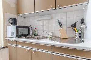 a kitchen counter with a sink and a microwave at Lovely 2 Rooms Next to Sint-Niklaas Very Central in Ghent +39 photos