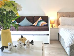 Un dormitorio con una cama y una mesa con un jarrón. en Morden Place, Free Parking & Private Entrance, en Bournemouth