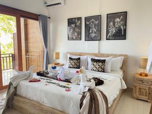 a bedroom with a large white bed with birds on it at Paradisehill Nusa Penida Resort in Klungkung +23 photos