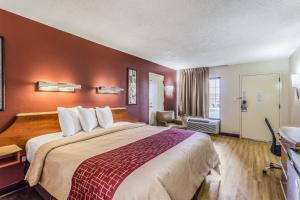 una camera d'albergo con un grande letto con pareti rosse di Red Roof Inn Bowling Green a Bowling Green